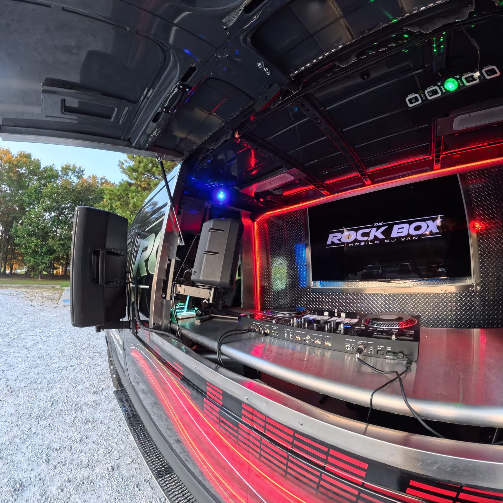 The Rock Box mobile DJ van interior set up as a DJ booth with LED lighting and a large video screen