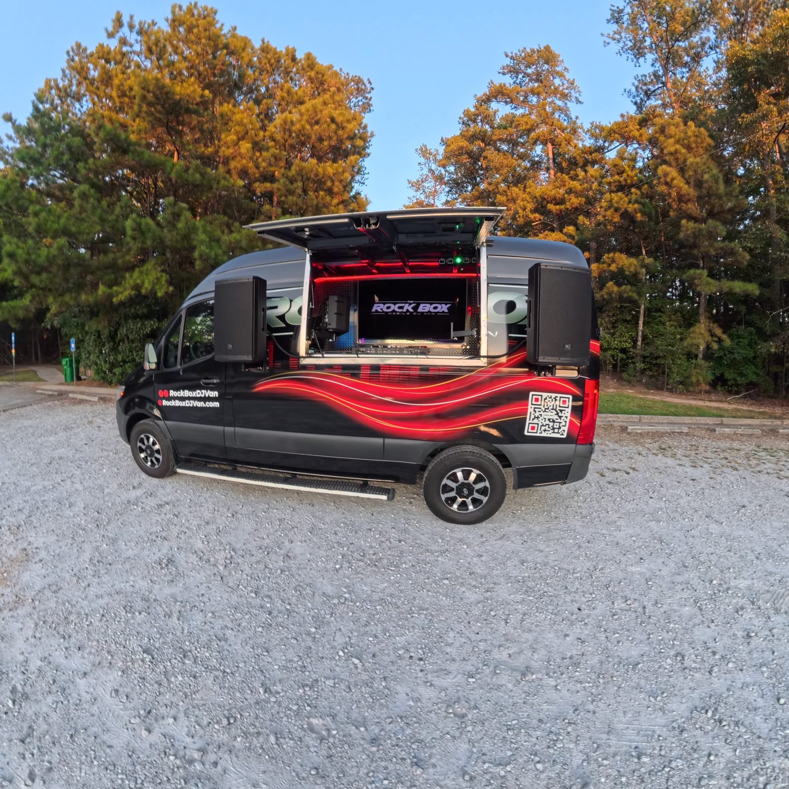 The Rock Box mobile DJ van with the side awning open and speakers set up for an event